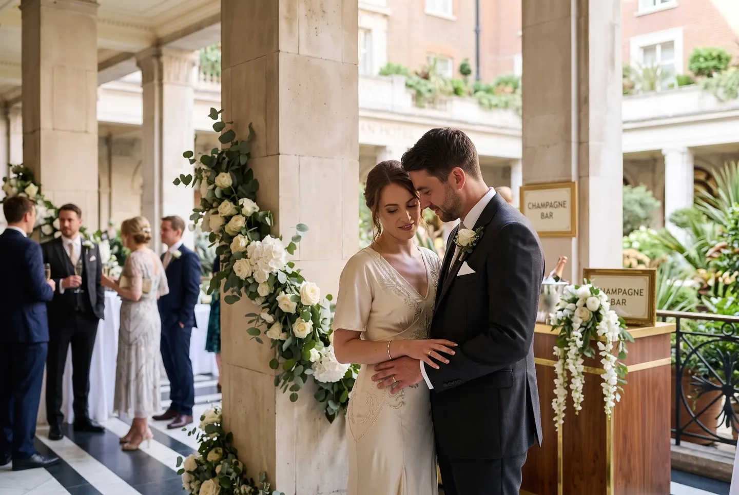A couple share a quiet moment between the stone columns of the Colonnade at Longman Hotel